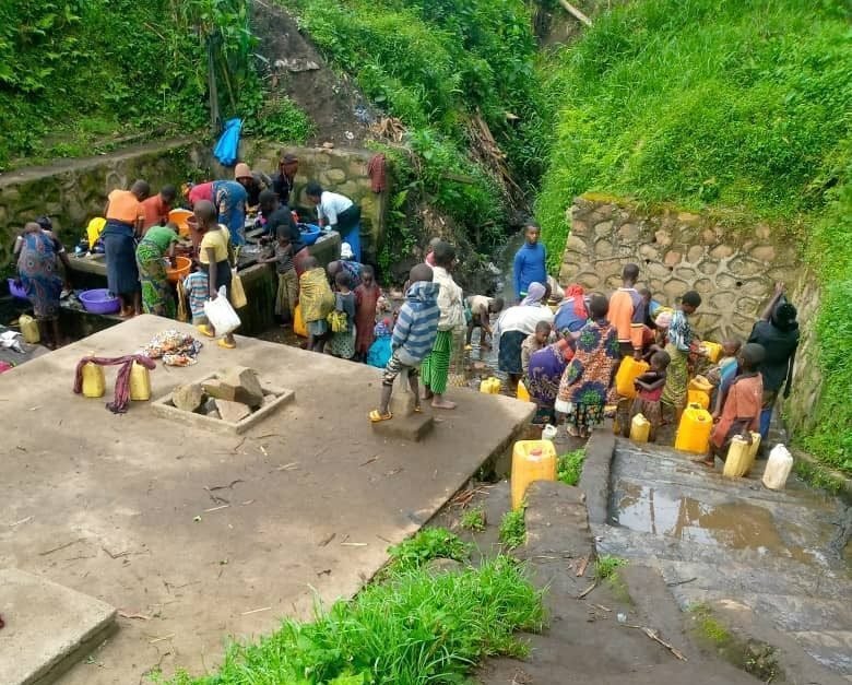 Families collecting water at a spring in North Kivu, DR Congo
