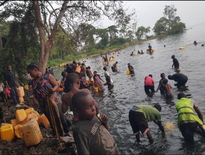 People wading into Lake Kivu to fill jerrycans, DR Congo