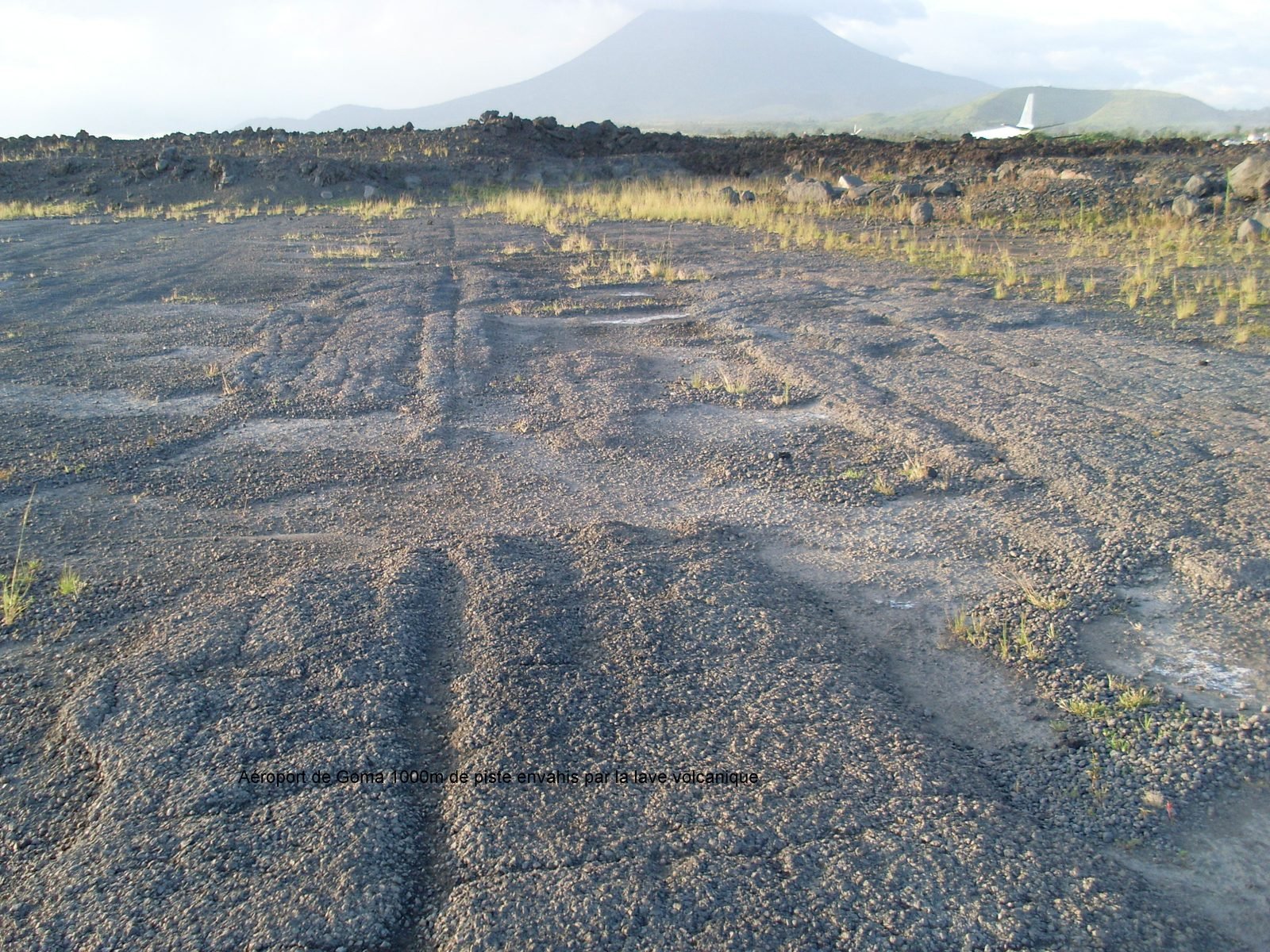 Hardened lava from the 2002 Nyiragongo eruption covering part of Goma airport runway, with the volcano behind