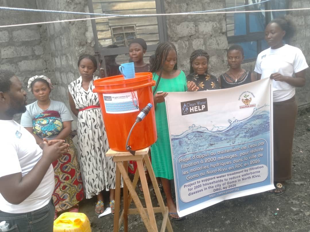 Women from neighboring households standing with their shared water filter in Goma, DR Congo